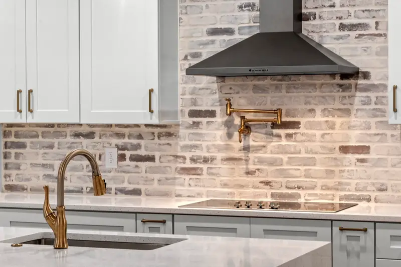 Kitchen detail with brick backsplash and brass fixtures