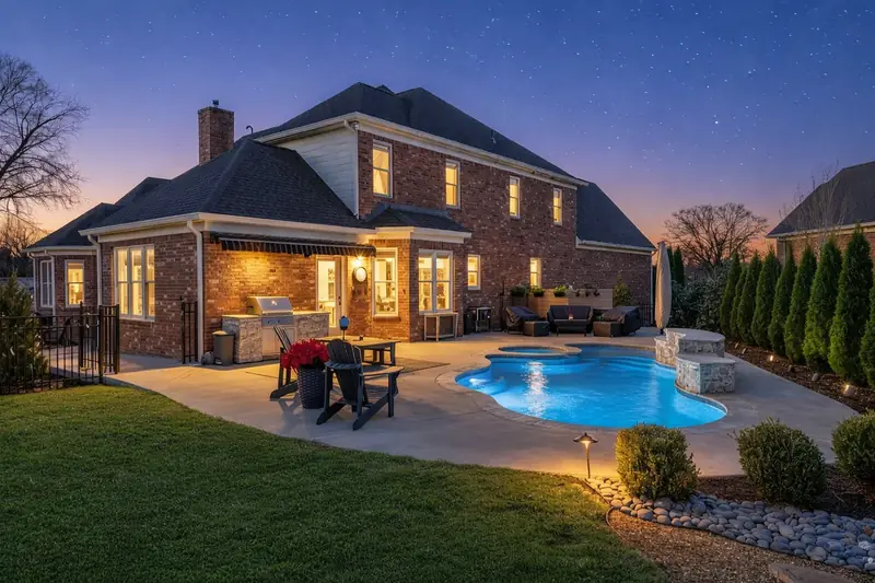 Backyard pool and patio photographed at blue hour