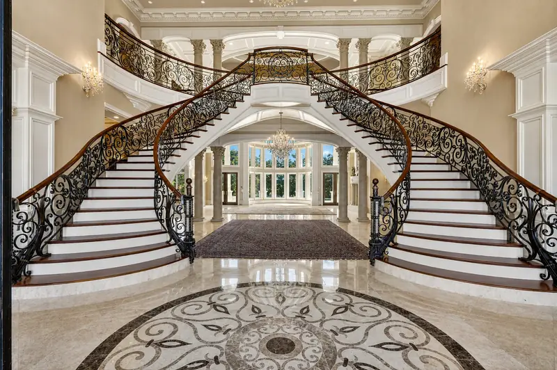 Double curved staircase in a marble entry hall