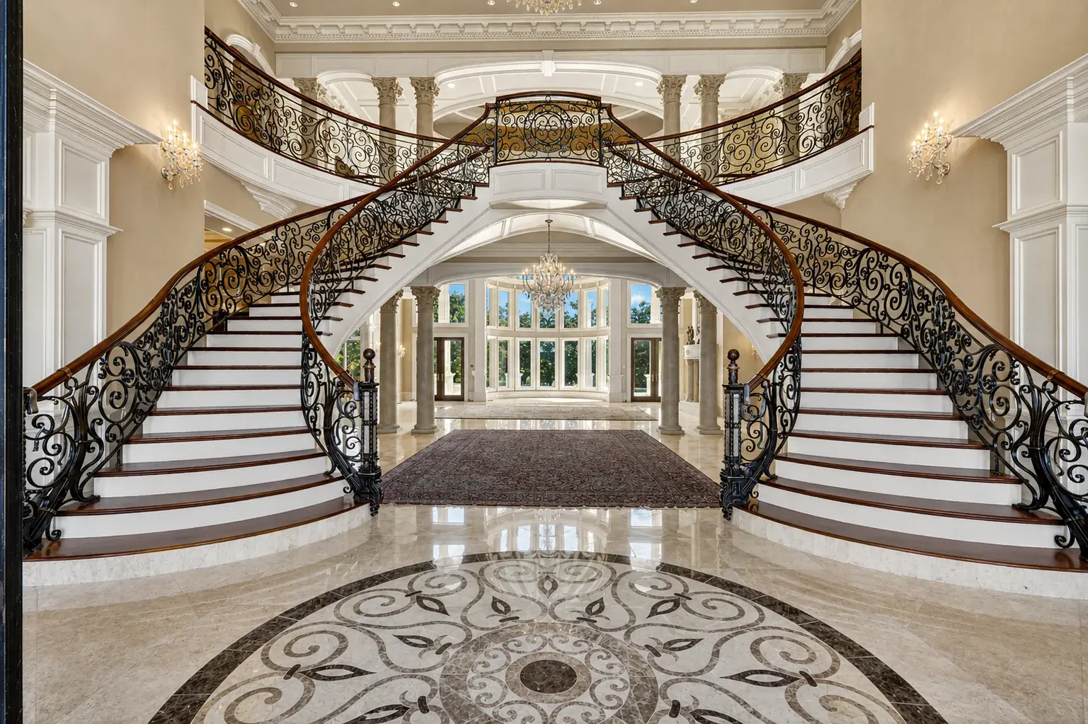Double curved staircase in a marble entry hall